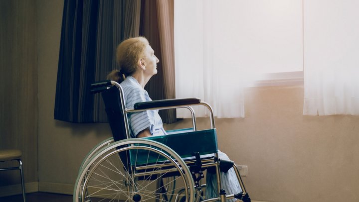 Retirement and Lonely women concept.Panoramic caucasian elderly woman in wheelchair while looking out the window in nursing home or hospital.