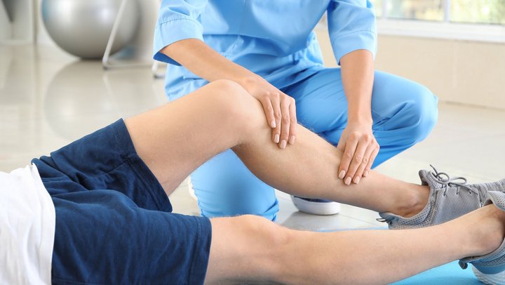 Physiotherapist working with male patient in rehabilitation center